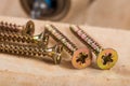 Pile of metal screws for wood with accu drill in the background