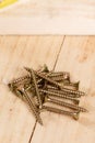 Pile of metar screws on the wooden planks background Royalty Free Stock Photo
