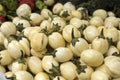 Pile of mini eggplants in a box for sale at a market