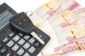 Pile of money beneath a calculator and a car key Royalty Free Stock Photo