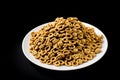 pile of muesli healthy cereal cornflakes in white bowl isolated on black background Royalty Free Stock Photo