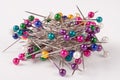 Pile of multi-colored sewing pins on a white background