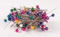 Pile of multi-colored sewing pins on a white background