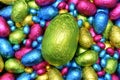 Pile of multi coloured and different sizes of colourful foil wrapped chocolate easter eggs in pink, blue, yellow and lime Royalty Free Stock Photo