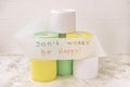 Pile of multicolored rolls of toilet paper on light background, supporting slogan, text. Concept of lack of toilet paper