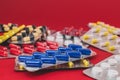 Pile of multicolored tablets on a red background Royalty Free Stock Photo