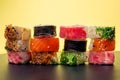 Pile of multiple hosomaki sushi on black and yellow background Royalty Free Stock Photo