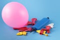 Pile of multiple colorful unblown balloons with a bliue pump over it