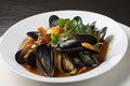 pile of mussels with steamy, savory broth and vegetables