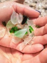 Green pieces of glass polished by the sea closeup background. Sea glass pieces in hand . A pile of natural beach glass. Multi- Royalty Free Stock Photo