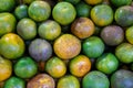 Pile of natural organic local thai tangerine orange fruit background in yellow, green color and marked skin texture