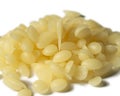 A Pile of Natural Yellow Beeswax Pearls isolated on a White Background