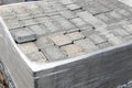 Pile of new grey paving stones on wooden pallet fixed with stretch wrap. Blocks texture, background, close-up. Royalty Free Stock Photo