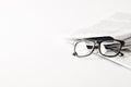 pile of newspapers with eyeglasses, on white background with copy space Royalty Free Stock Photo