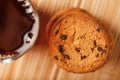 A pile of oatmeal cookies with chocolate chips and a mug of fragrant black hot tea in on a bamboo substrate, on a dark background Royalty Free Stock Photo