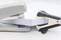 Pile of office paper, black staple remover and gray stapler on white background, concept abstract background