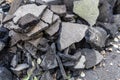 A pile of old asphalt debris. Replacement of the old asphalt surface on a road or sidewalk. Dust, dirt, debris, and old