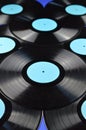 Pile of old black vinyl records on blue background