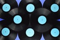 Pile of old black vinyl records on blue background