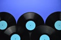 Pile of old black vinyl records on blue