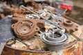 A pile of old broken pieces of iron lying on a rusty barrel