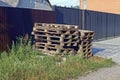 A pile of old brown wooden pallets in green grass