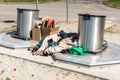 Pile of old clothes and shoes dumped on the underground dumpster cans as junk and garbage, littering and polluting the urban city Royalty Free Stock Photo