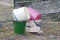 A pile of old colored plastic and metal buckets stand on the ground Royalty Free Stock Photo