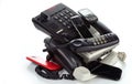 A pile of old desk phones, cordless phones, and smartphones