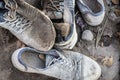 A pile of old dirty shoes lies on the ground. Worn out shoes. Poverty and misery concept Royalty Free Stock Photo