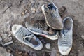 A pile of old dirty shoes lies on the ground. Worn out shoes. Poverty and misery concept Royalty Free Stock Photo