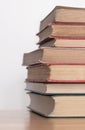 Pile of old dusty books on a wooden surface Royalty Free Stock Photo