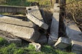 Pile of old log concrete slabs lie in the green grass