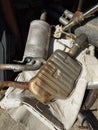 A pile of old rusted car exhausts, silencers, or tail pipes in the backyard of an auto repair shop. Top view, no people