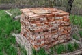 A pile of old used bricks lies on the ground among green young grass in spring Royalty Free Stock Photo