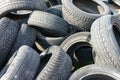 A pile of old used rubber car protector tires at auto service or dump with rubbish and waste ready for recycling