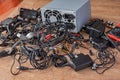 Pile of old wires, connections, headphones and chargers on a wooden table close-up. Replacement of old elements and parts of