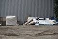 Pile of old worn-out mattresses on the ground along the back fence