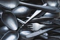 Pile of old worn vintage cutlery. Background of aluminium forks and spoons. Top view Royalty Free Stock Photo