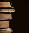 A pile of an old yellowed with age books on the black background Royalty Free Stock Photo