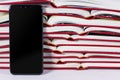 Pile of opened books with smartphone