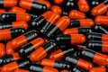 Pile of orange-black capsule pills. Antibiotics resistance. Drug use with reasonable. Global healthcare concept. Antibiotics drug Royalty Free Stock Photo