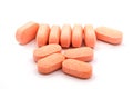 Pile of orange pills of vitamins on white background