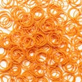 Pile of orange rubber bands scattered on white background Royalty Free Stock Photo
