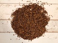 A pile of organic buckwheat husks used as a filling for buckwheat pillow on a wooden planks background Royalty Free Stock Photo