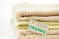 Pile of organic cotton bath towels on white background.