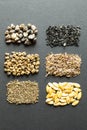 Pile of organic seeds on a black background: rhubarb, lettuce, beets, spinach, onion, dill, melon, carrot, fennel. Vertically