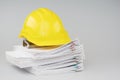 Pile overload document have yellow engineer hat on top