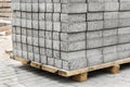 A pile of packed paving stone slabs industrial tile sidewalk materials on wooden pallet at a construction site