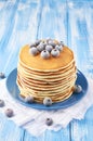 Stack of pancakes on a blue plate with frozen blueberry